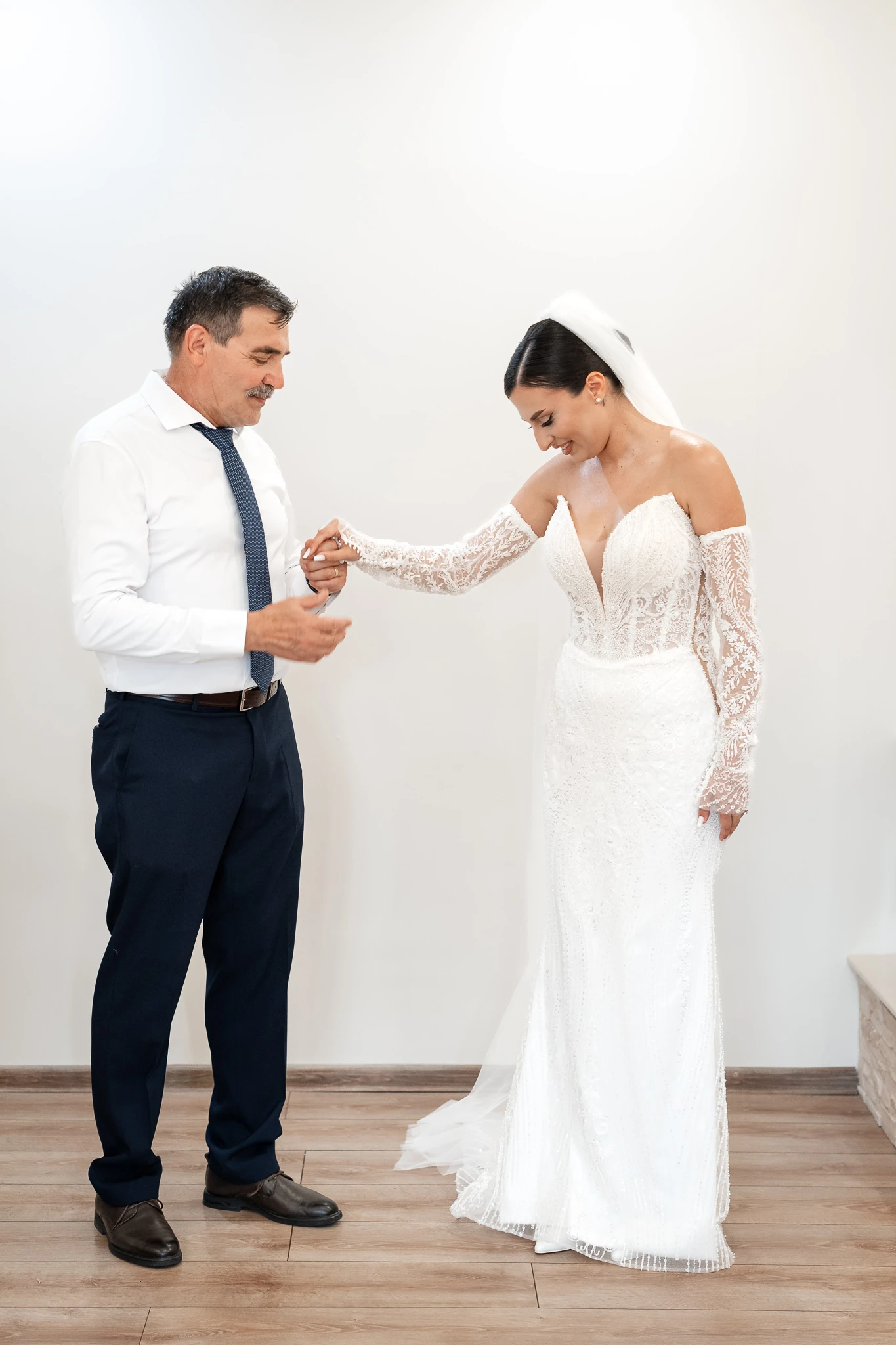 Mireasa Mara ține de mâini un bărbat în cămașă albă la pregătirile din Țăndărei