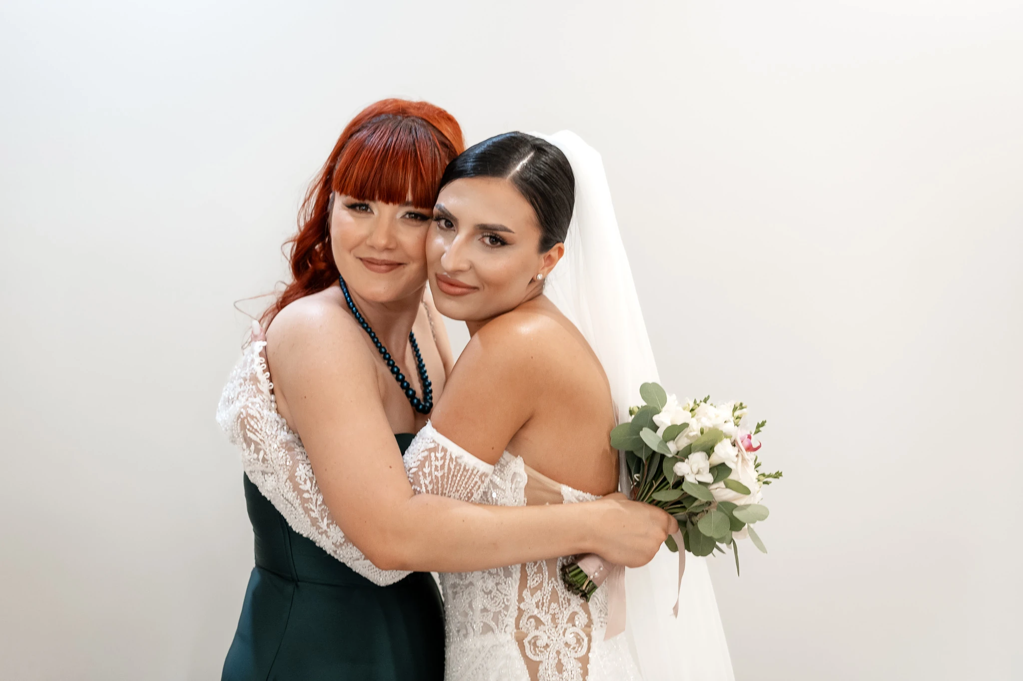 Mara îmbrățișează o femeie în rochie verde, cu buchetul în mână, la pregătiri în Țăndărei