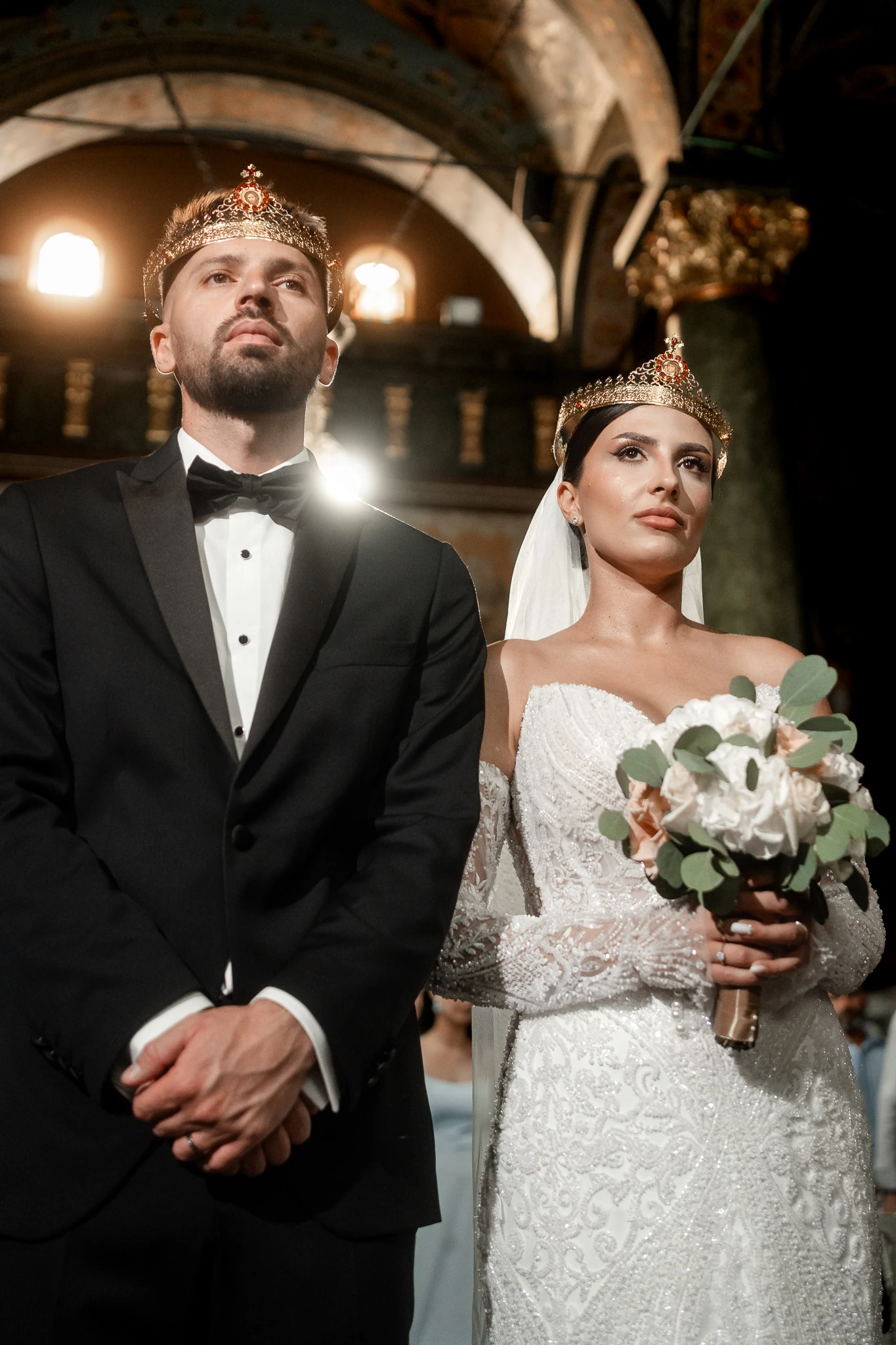 Mireasa și mirele sub bolta bisericii, cu cununiile pe cap, la nunta din Hârșova